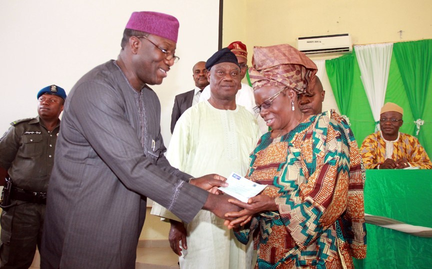PENSION Ekiti State Governor, Dr Kayode Fayemi; Chairman, State Pension Commission, Mr. Oluwole Ojo; and a beneficiary, Mrs. Eunice Komolafe, during the distribution of cheques to Pensioners by the Governor, in Ado-Ekiti... on Friday.