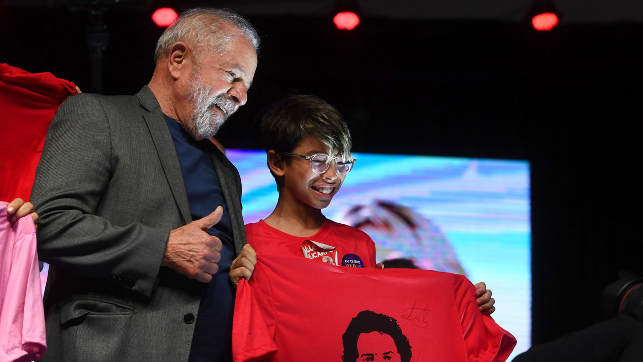 Brazilian presidential pre-candidate for the leftist Workers Party (PT) and former President (2003-2010) Luiz Inacio Lula da Silva (L), poses with a child during a political rally in Brasilia, on July 12, 2022. (Photo by EVARISTO SA / AFP)